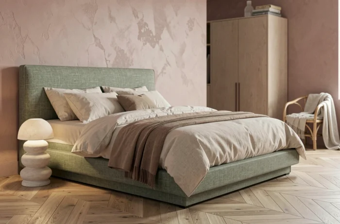 Contemporary bedroom with a sage green linen headboard, powder pink wash walls, and trendy natural rattan furniture for 2024